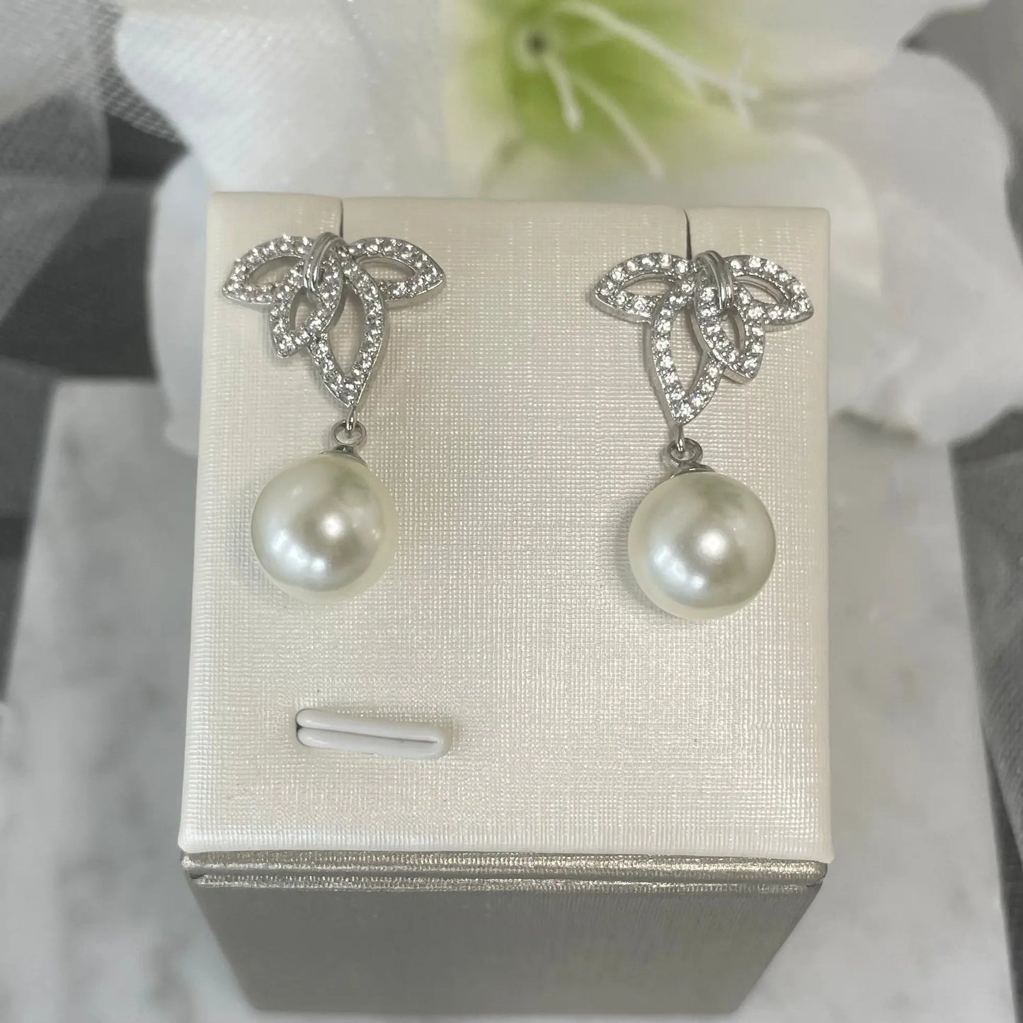 Belmont crystal pearl earrings with leaf design, varied crystal sizes, and a unique central hole, culminating in a classic pearl drop, ideal for bridal elegance.