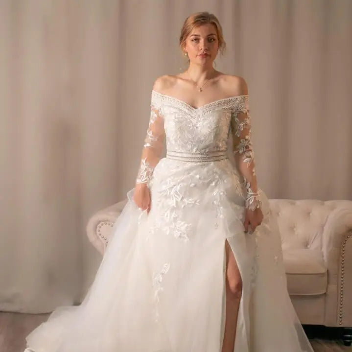 Diana off-shoulder lace ballgown wedding dress with heart V-shaped neckline and horsehair-edged hem.