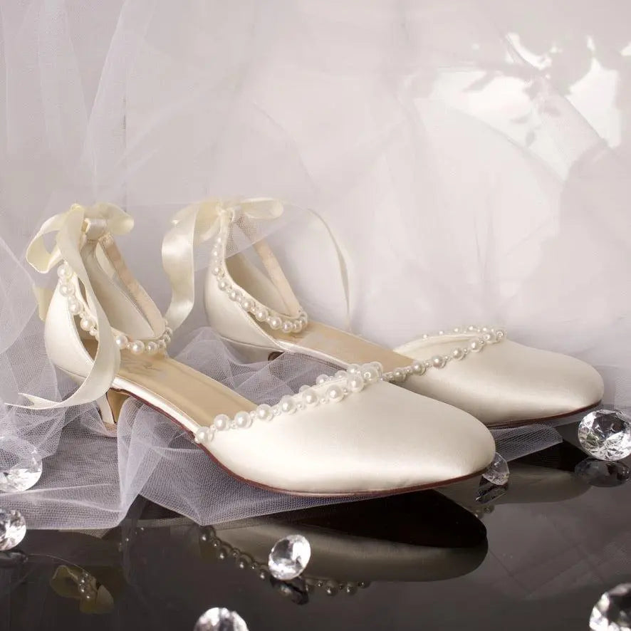 Dixie Bridal Shoe Pair Side View: Side view of two Dixie Pearl Closed Toe Ankle Strap Wedding Bridal Shoes showcasing the satin bow and ankle strap.