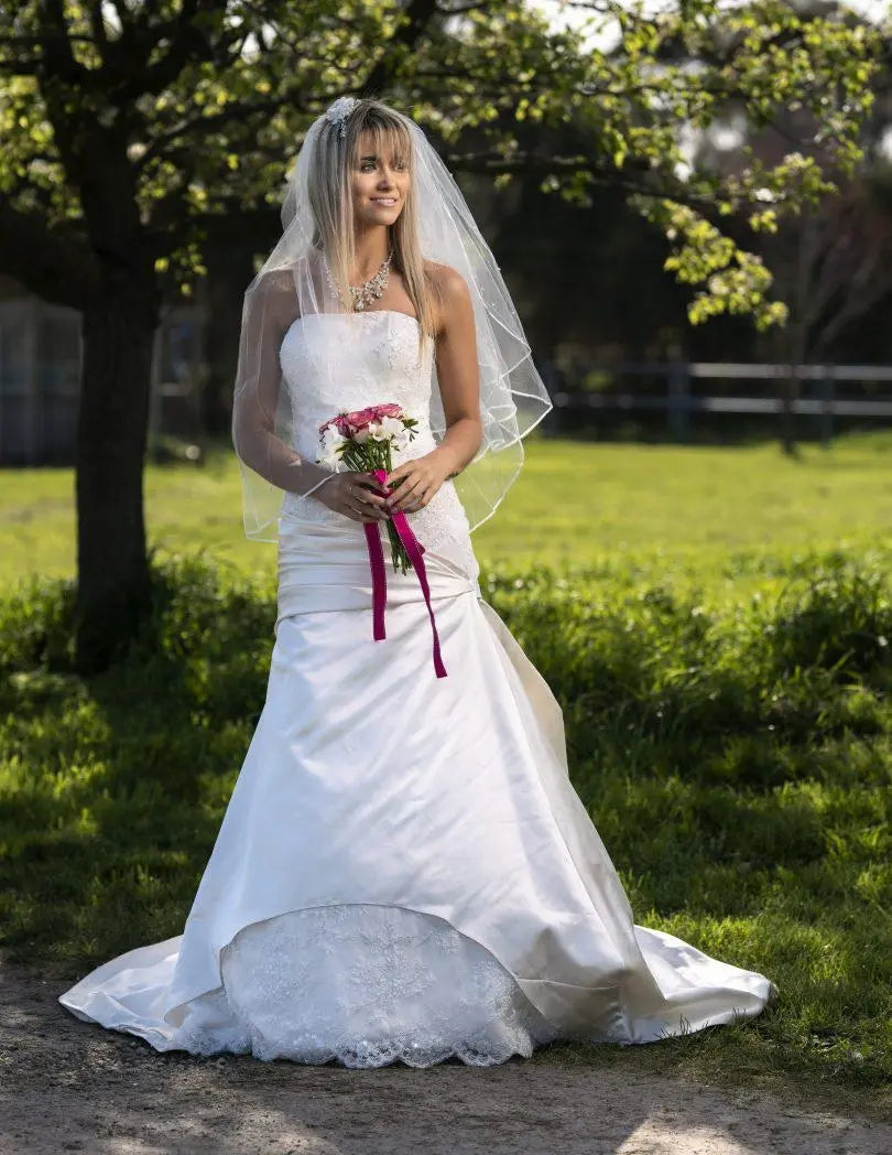 Elara Gown Full Front: Full front view of the Elara Gown with a farm in the background, highlighting its elegant silhouette.