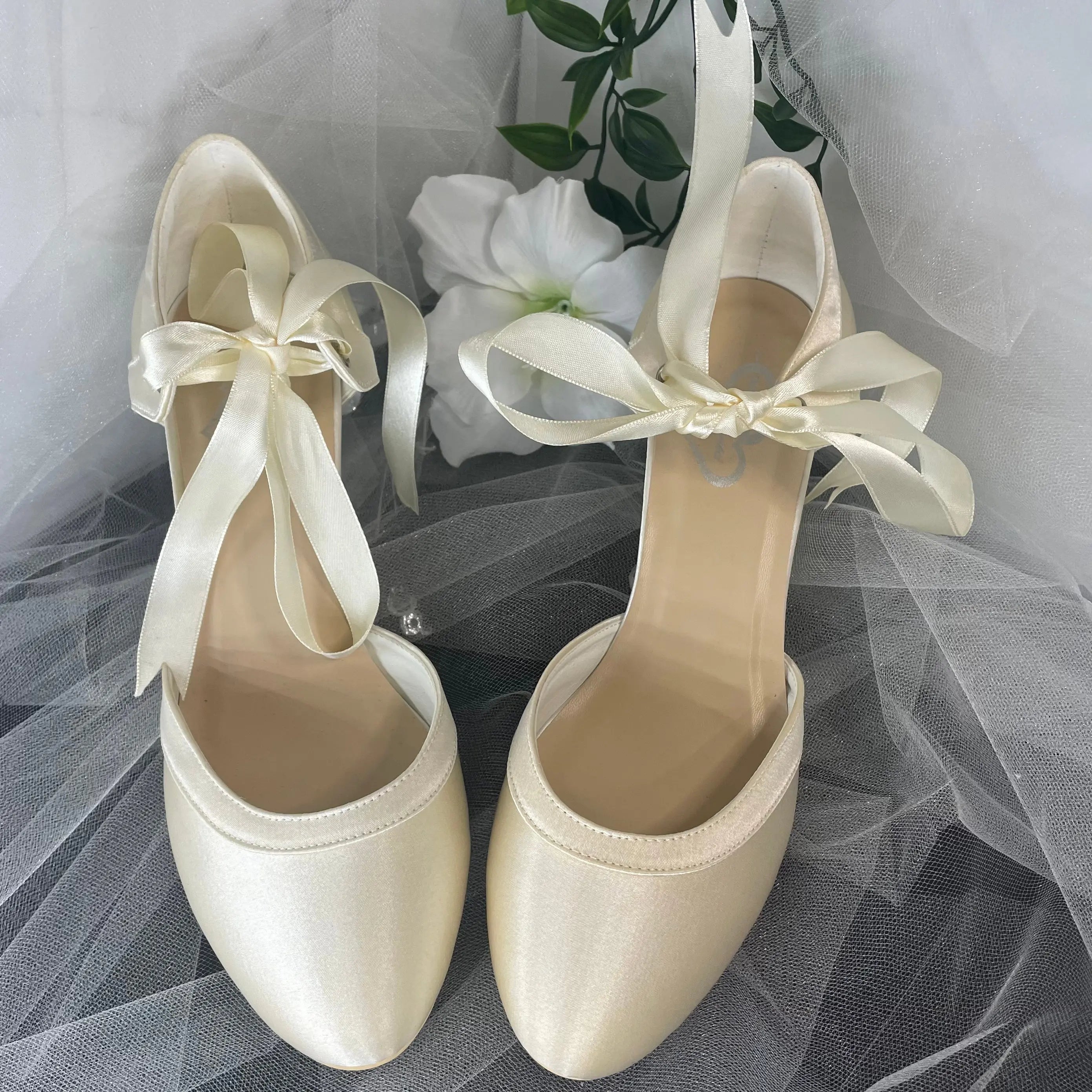 Ellie Bridal Shoe Pair Front Close-Up Different Color: Close-up front view of two Ellie Closed Toe Ribbon Ankle Strap Wedding Bridal Shoes highlighting the ribbon bow and color difference.