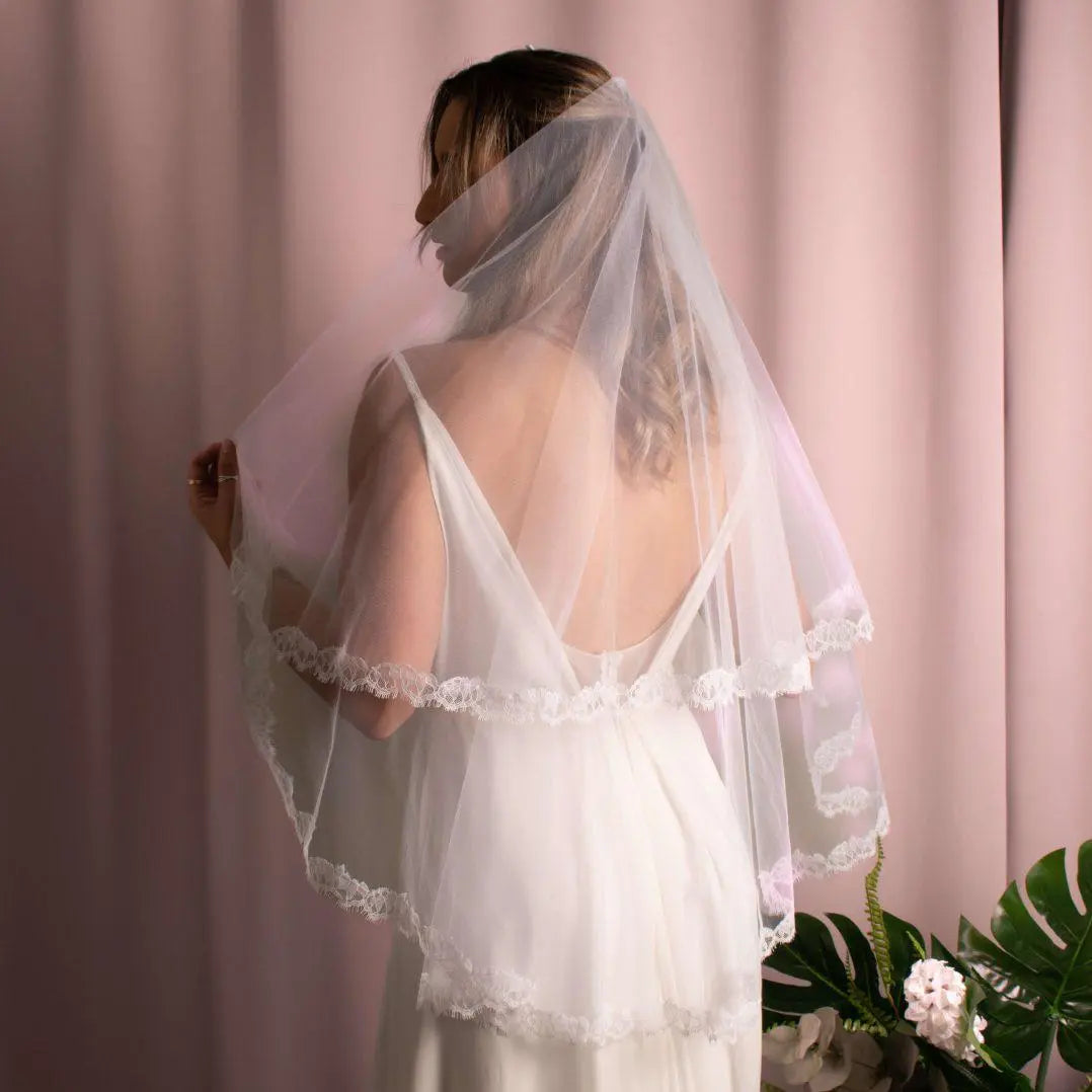 Elliott Lace Trim Veil in fingertip length with lace edging, made of soft American tulle, draped elegantly over the face.