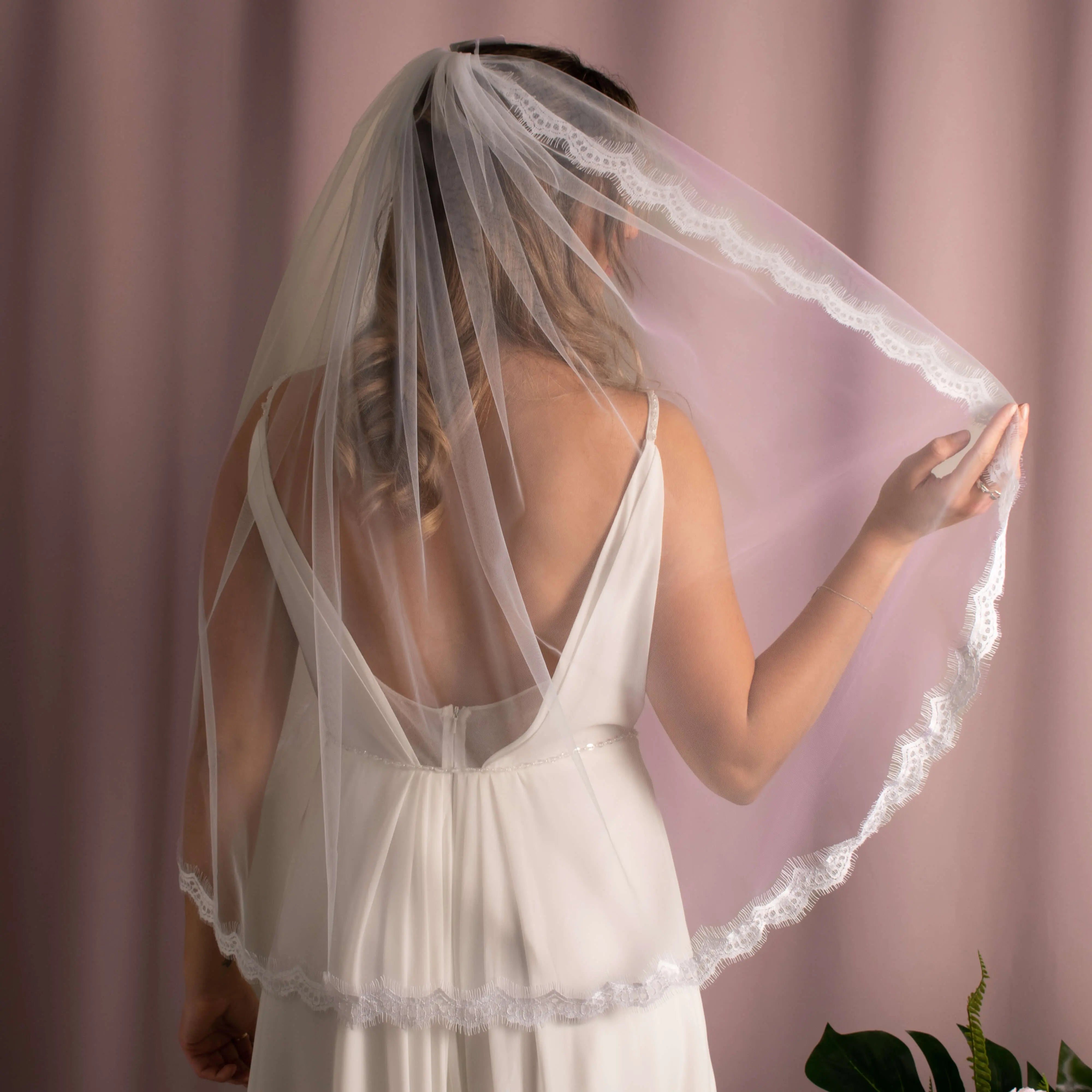 Elegant Elora Lace 1Tier Veil in soft tulle with lace edging, attached to a comb for a glamorous bridal look.