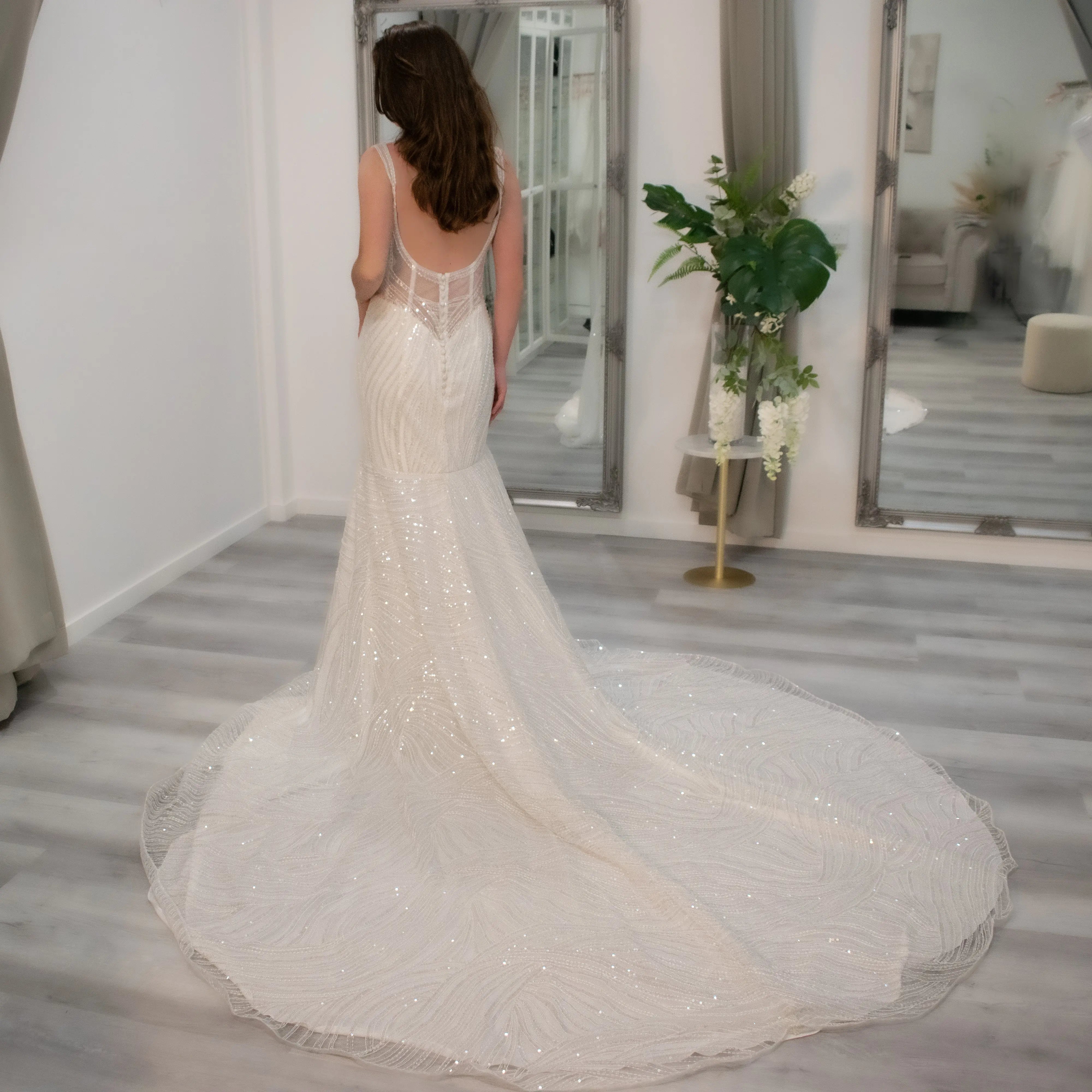 Bride wearing Enchantia wedding gown with elegant silhouette. Back view featuring invisible zip and vintage buttons