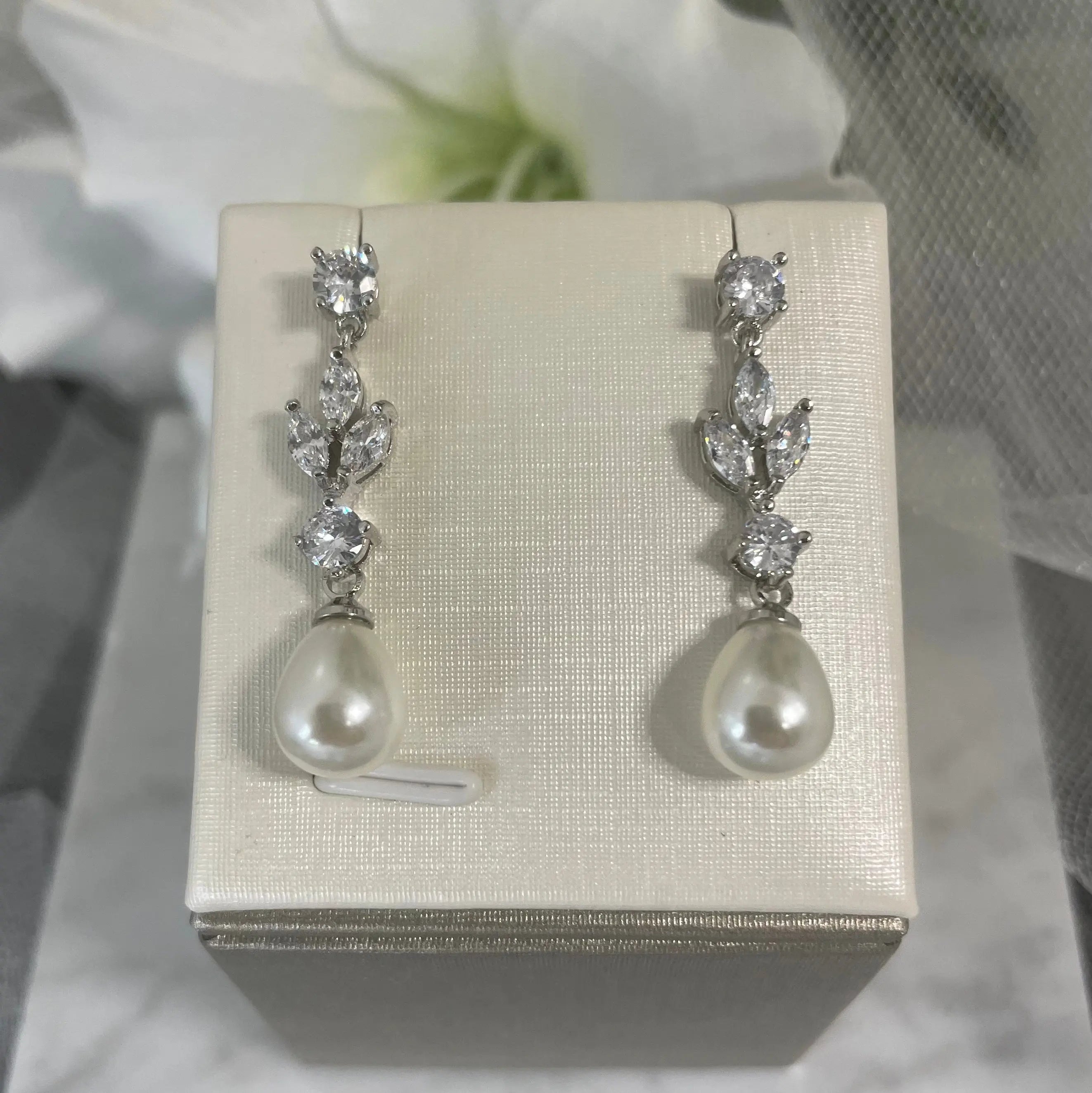 Evelyn Drop CZ & Pearl Earrings (Close-Up - Silver): A close-up view of the Evelyn Drop CZ & Pearl Earrings in silver, showcasing the sparkling CZ stones and delicate teardrop pearl.