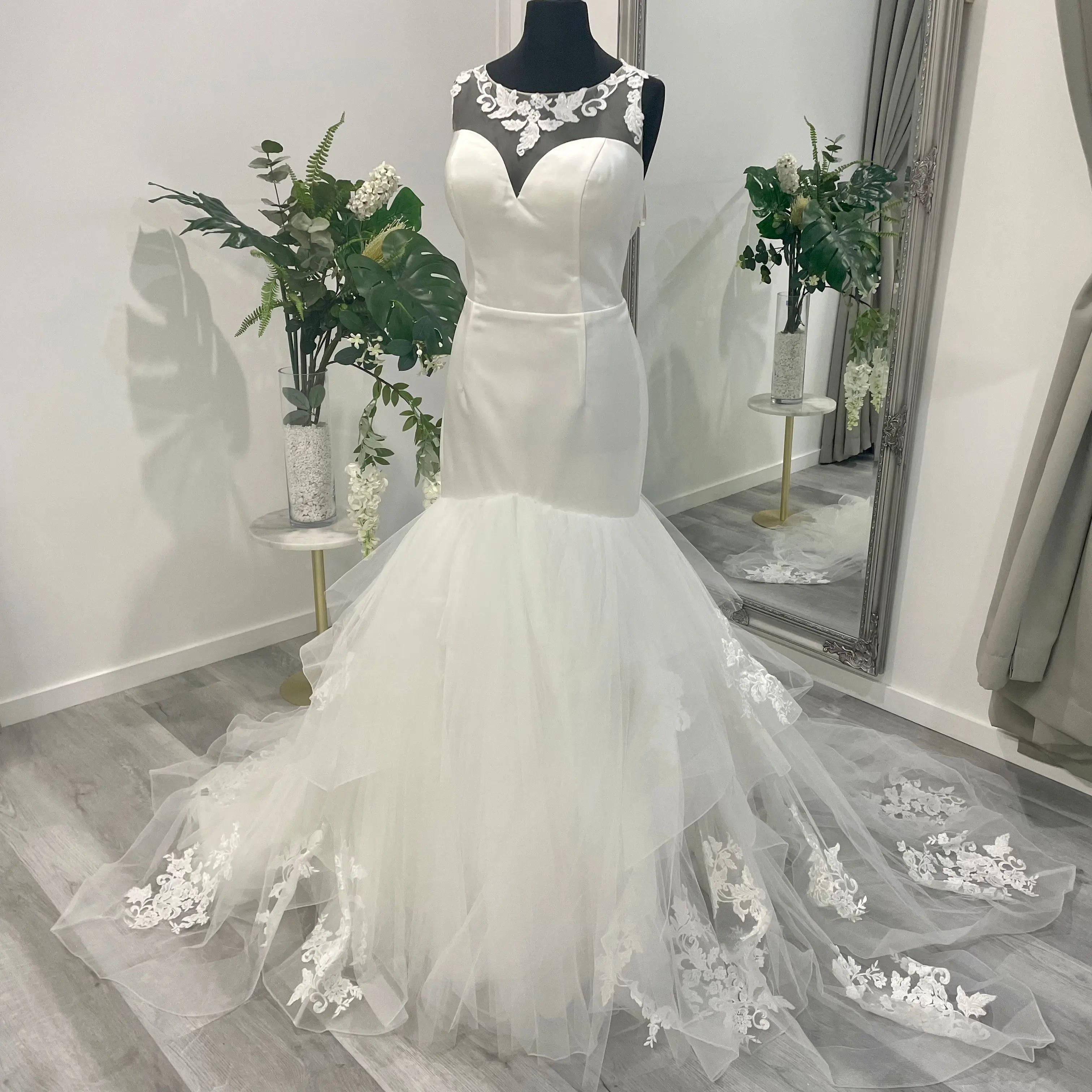 Chic Iris Trumpet bridal gown with intricate lace detailing and a flowing mermaid silhouette on display at Divine Bridal.