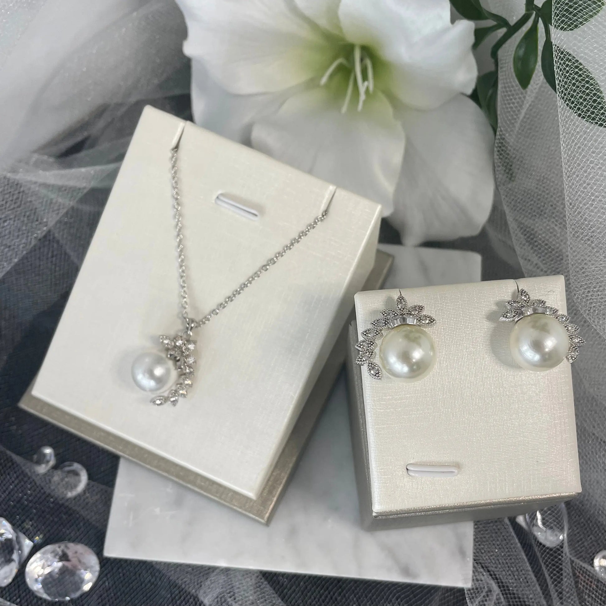 Gloria Necklace & Earring Set: A classic pearl and CZ jewelry set featuring a necklace and earrings with a center pearl and scattered CZ leaves, perfect for special occasions.