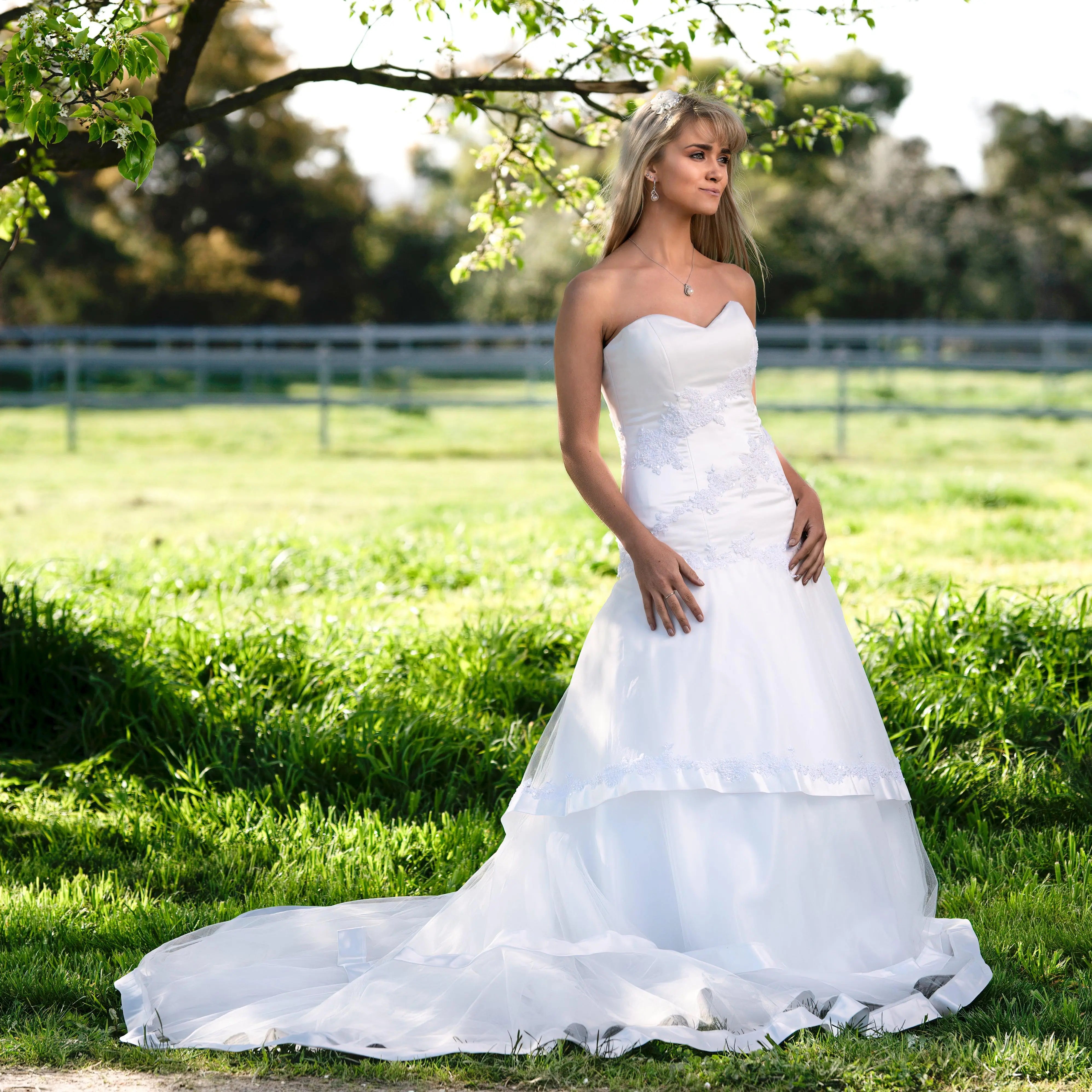 Hazel Bridal Gown Front View: Bride in 'Hazel' Strapless Lace Mermaid Gown with Tulle Skirt, showcasing the front view with floral lace appliqué and beading.