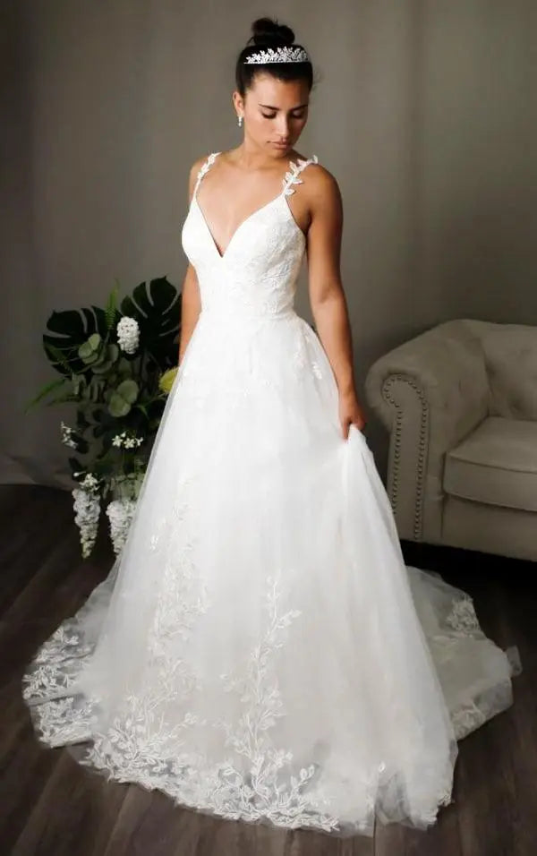 Bride in Holly, a floral leaf lace adorned A-line bridal gown with deep V-neckline, lace straps, and a keyhole back.