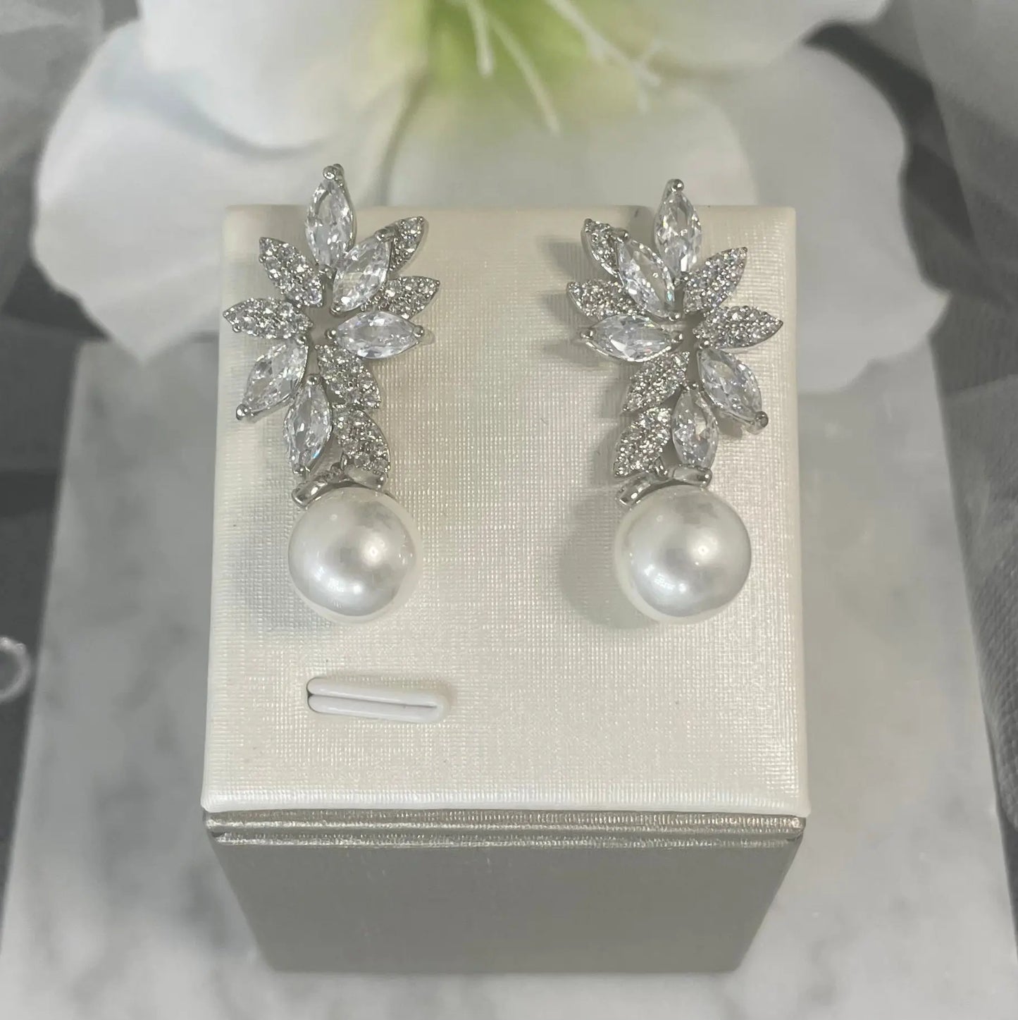 Indi crystal pearl earrings with floral and leaf motifs, featuring delicate crystals and a drop pearl, set in sterling silver, perfect for enhancing wedding and special occasion attire.