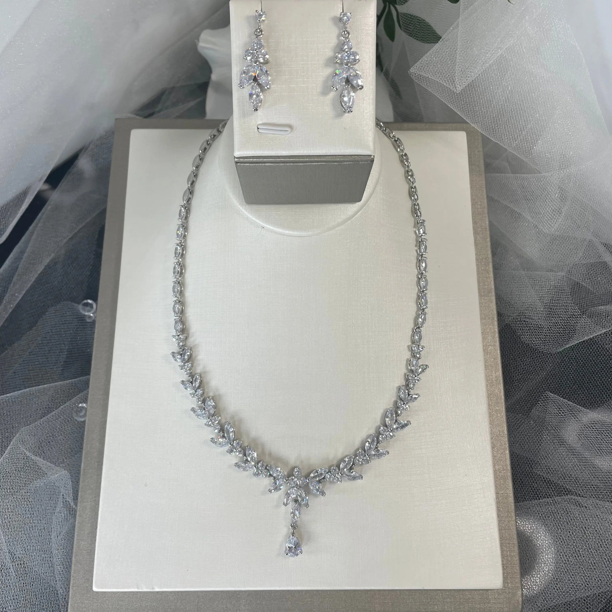 Silver Necklace and Earrings: A beautiful silver necklace and earrings set featuring leaf and flower designs with clear cubic zirconia.