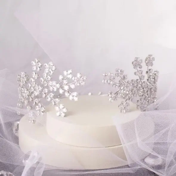 Elegant Lena Bridal Tiara with shimmering floral blossoms and silver crystal CZ embellished leaves, cascading delicately over the side of the headband, perfect for a glamorous bridal hairstyle.