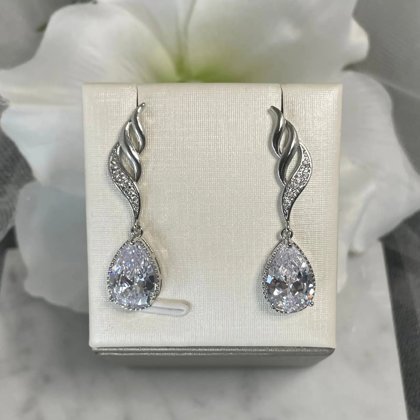 Marie crystal earrings featuring a three-wave design with delicate crystals and a teardrop pendant, available in 18k gold/Silver and Rose gold platings.