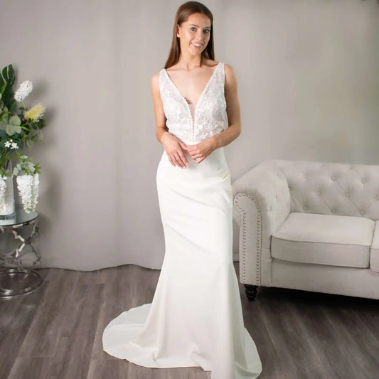 Meredith Gown Front View: Front view of the Meredith Wedding Dress showcasing its plunging V-neckline and sheath silhouette.