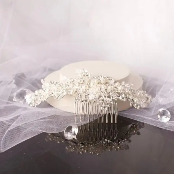 Stunning Polly Crystal Pearl Bridal Hair Comb, featuring clusters of shimmering pearls and diamantés on a chic silver base, ideal for enhancing bridal hairstyles with elegance and sparkle.