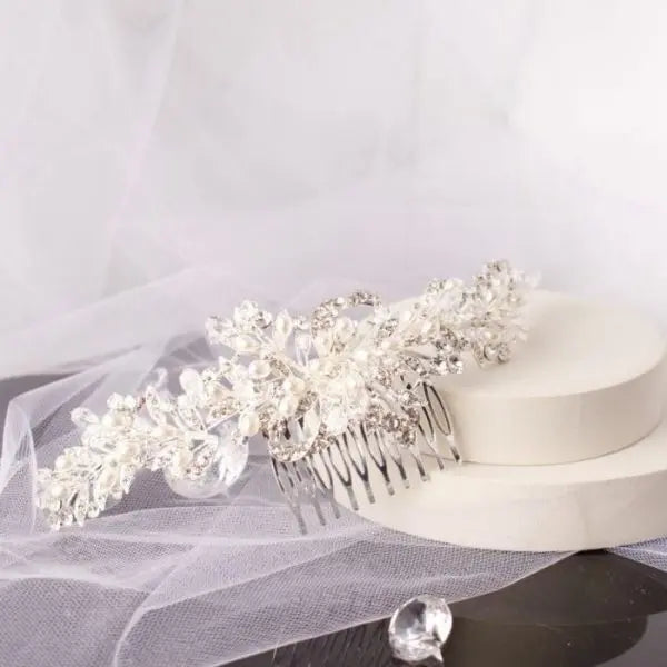 Stunning Polly Crystal Pearl Bridal Hair Comb, featuring clusters of shimmering pearls and diamantés on a chic silver base, ideal for enhancing bridal hairstyles with elegance and sparkle.