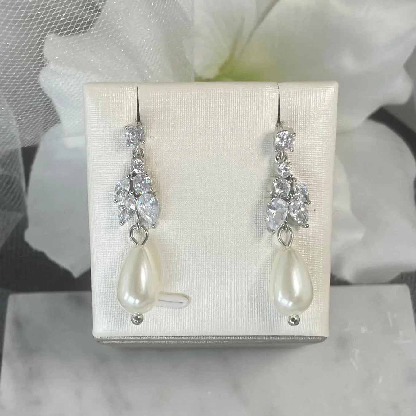 Sadie crystal pearl earrings with round top crystal, leaf-like crystal cluster, and teardrop pearl, perfect for adding timeless elegance to bridal attire.