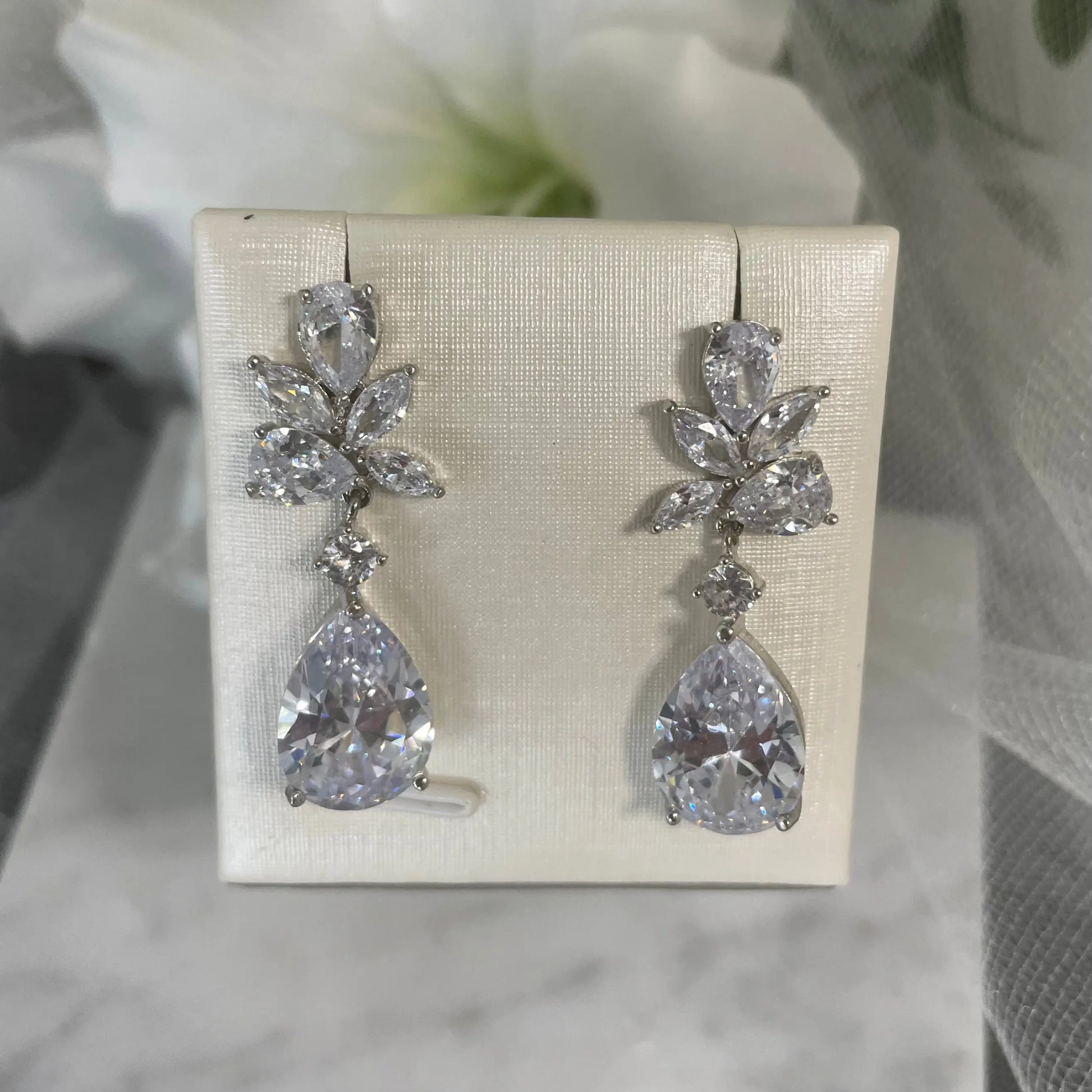 Tegan teardrop crystal earrings with a unique scattered crystal design in rhodium-plated metal, ideal for brides and bridesmaids seeking elegant and distinctive bridal jewelry.