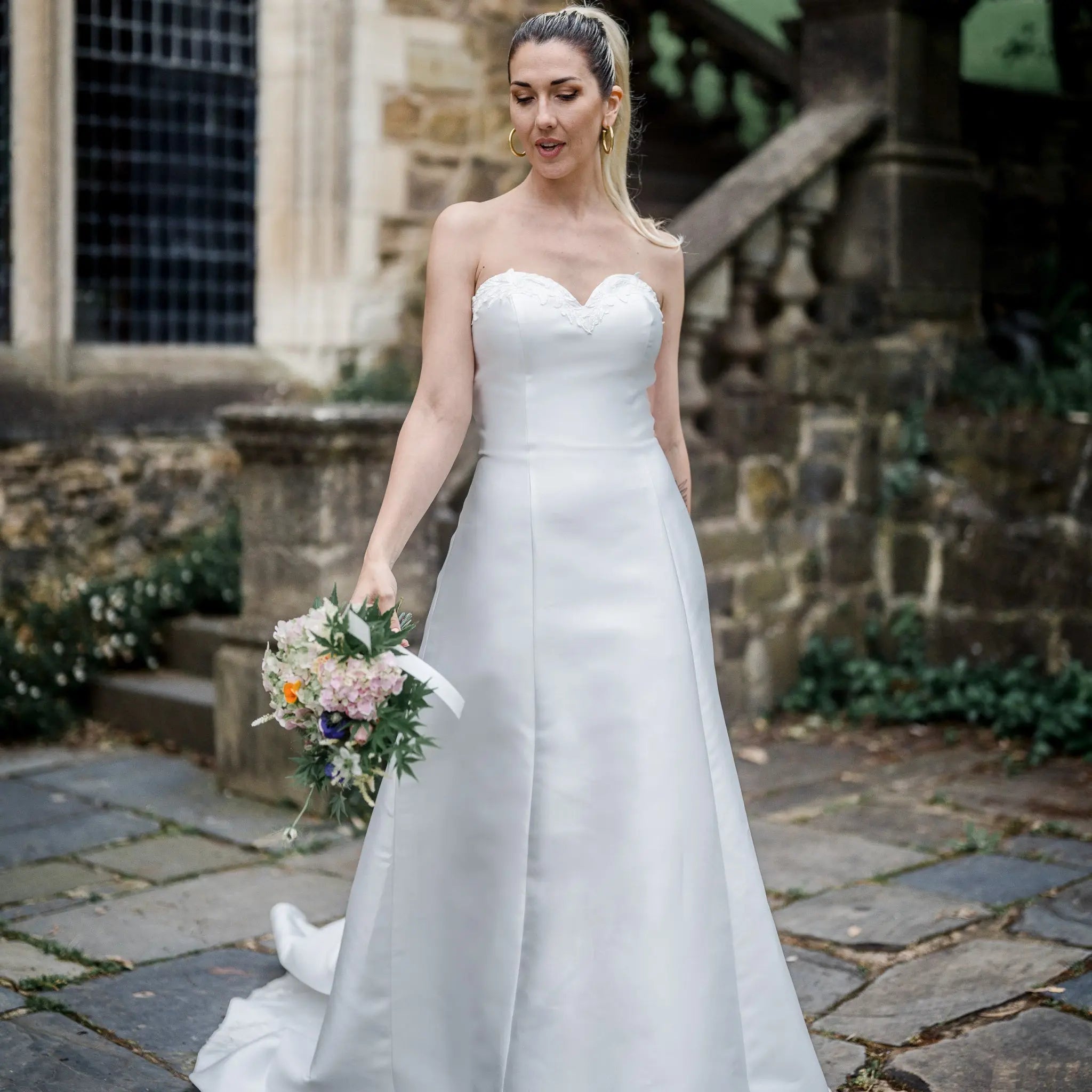 Summer wedding dress with a lace-adorned sweetheart neckline, detachable sleeves, and a flowing train.