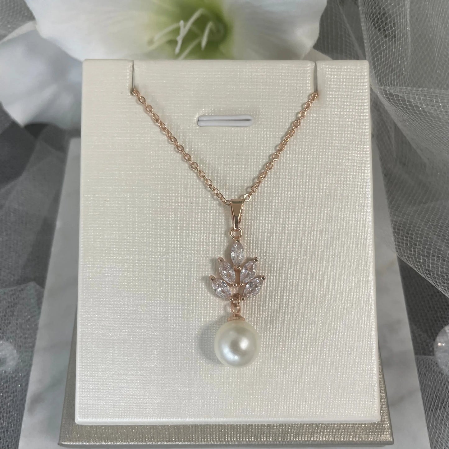 Necklace in Rose Gold: A stunning rose gold necklace with a leaf design and a teardrop pearl pendant.