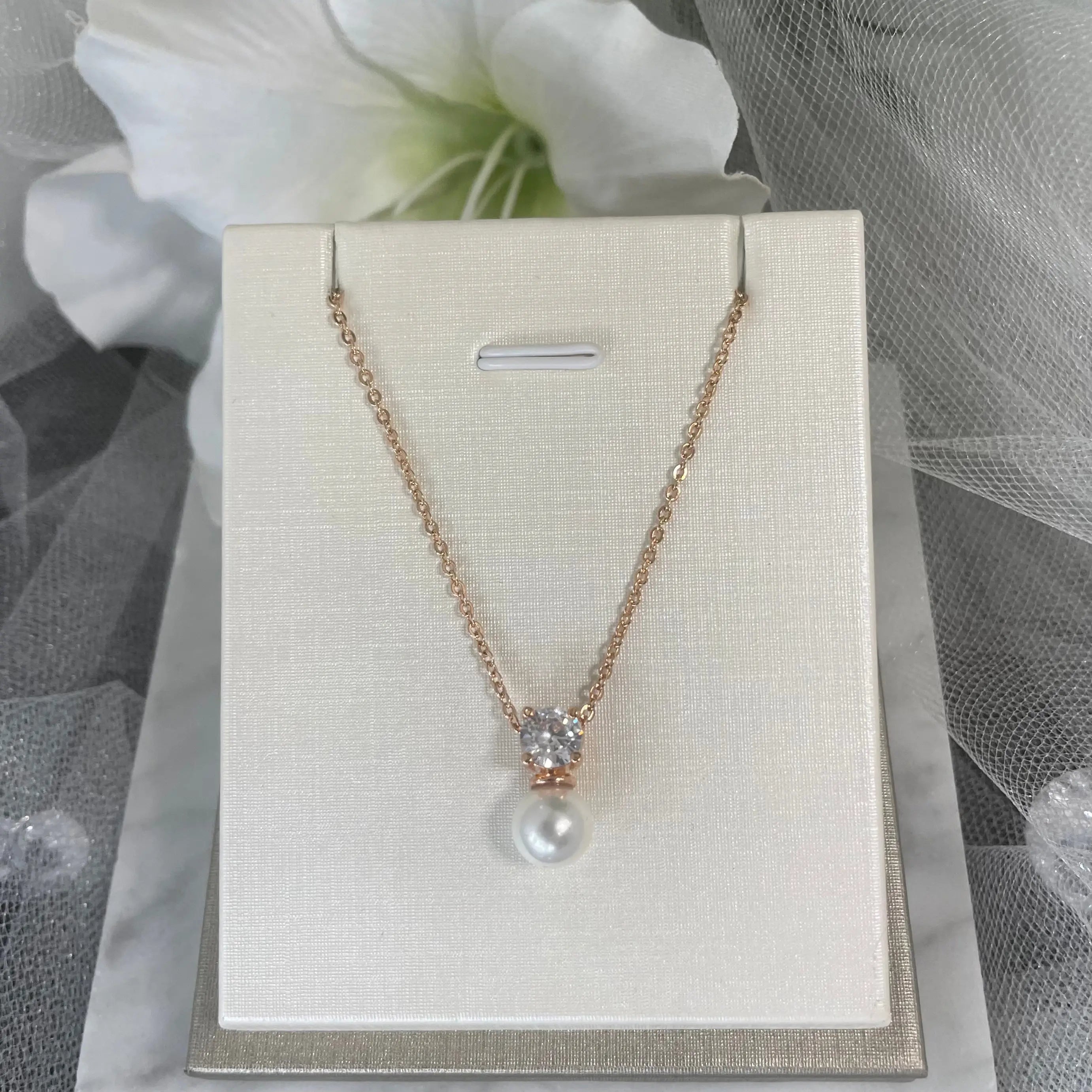 Zara Pearl & Diamond Necklace (Rose Gold): A stunning rose gold necklace with a pearl drop and square diamante, set on a FIGARO chain, perfect for weddings.