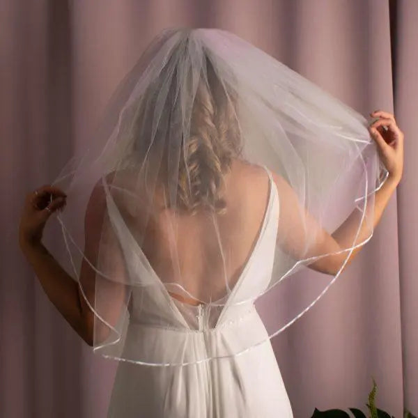 Bride beautifully adorned with the Zara Ribbon Edge Veil.