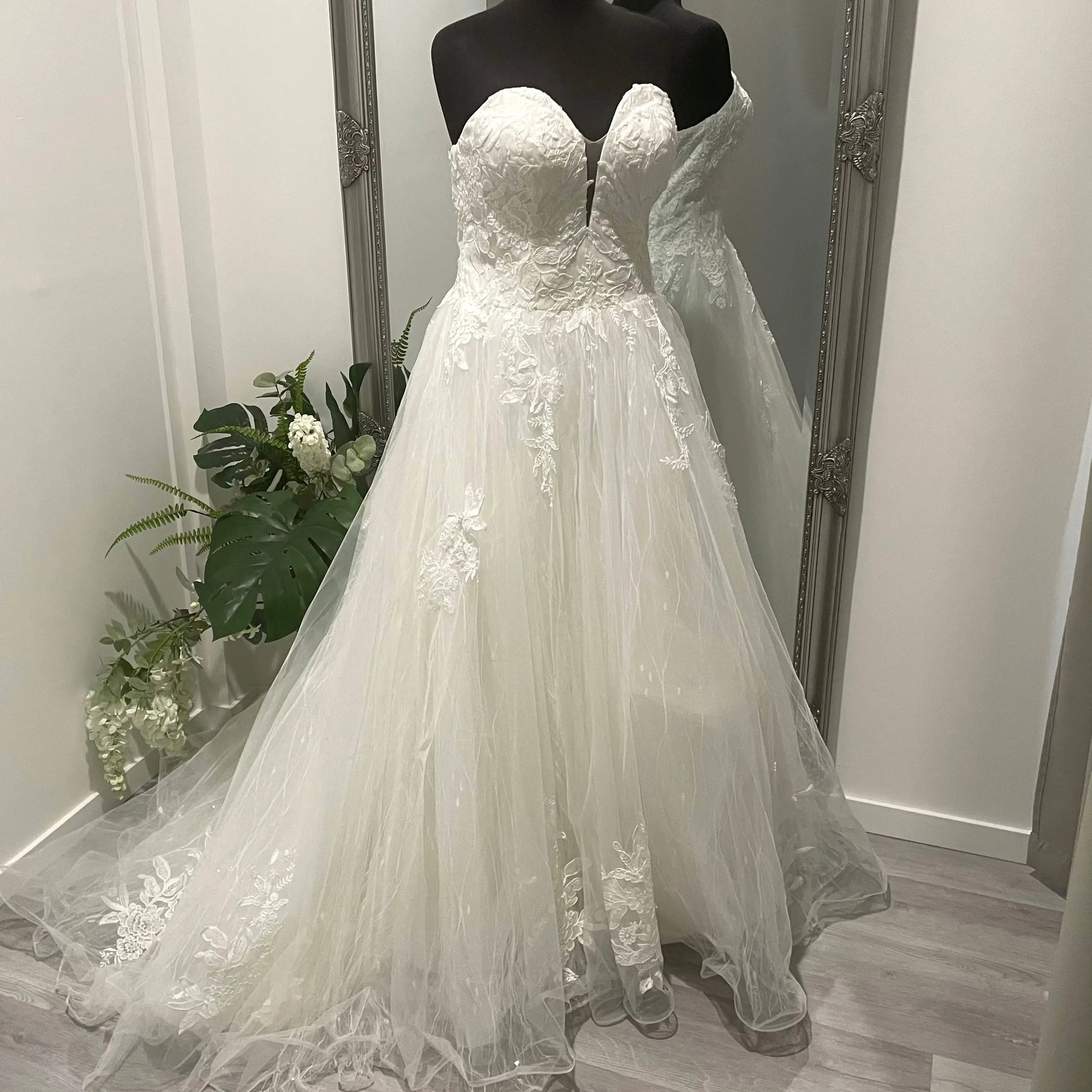 Front view of the Kate wedding gown featuring a sweetheart neckline with a plunging center, adorned with illusion skin tone tulle and lace appliqué, creating a stunning and elegant bridal look.