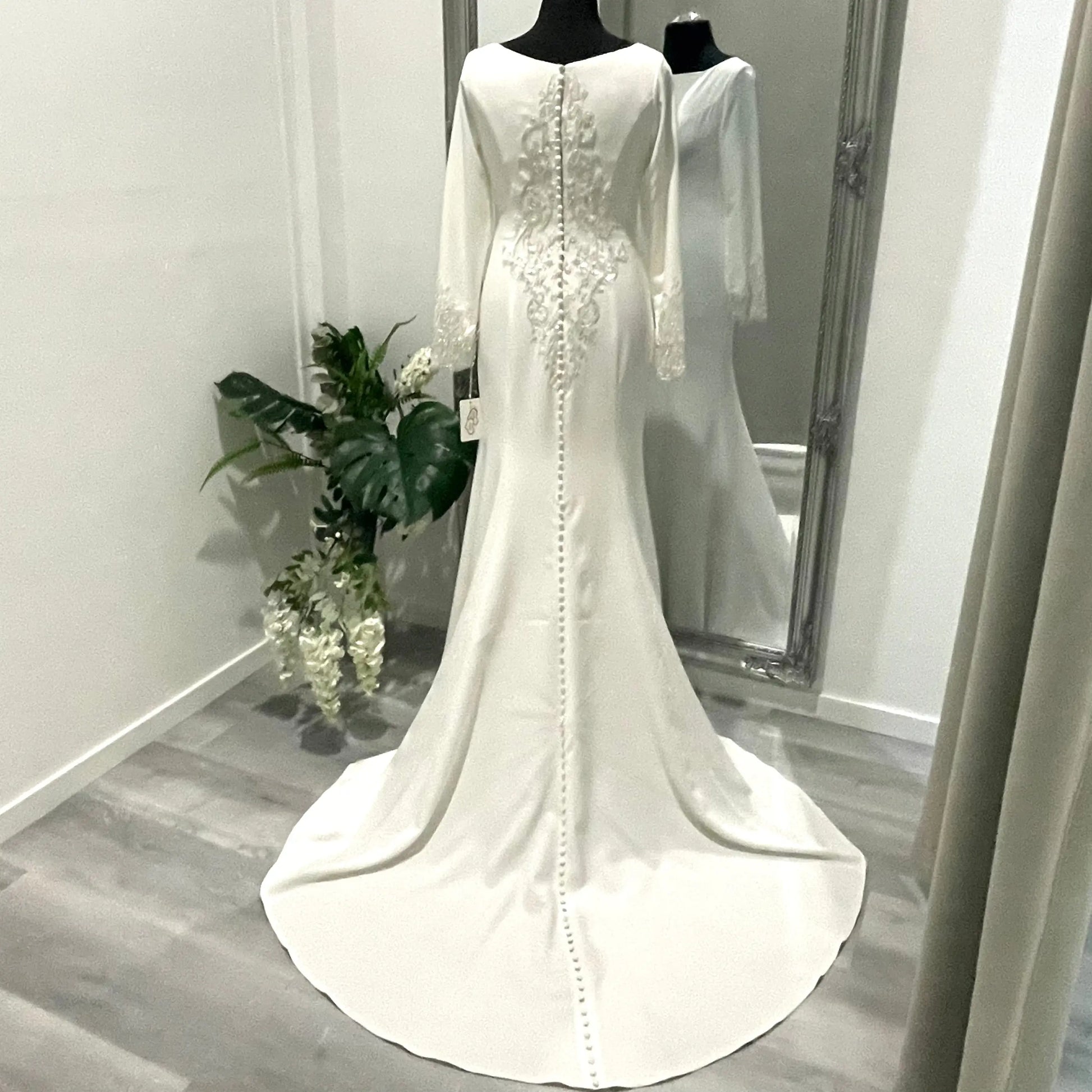 Back view of the Krysta wedding gown showcasing its intricate lace appliqué and illusion bodice, embodying classic bridal charm and timeless elegance.